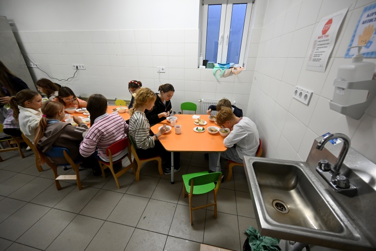 Des écoliers déjeunent dans la cantine d'un abri au sous-sol de leur établissement scolaire pendant une alerte aérienne dans la banlieue de Kiev, le 20 octobre 2026
