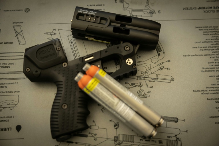 Un pistolet lacrymogène JPX4 LE, une arme de défense de catégorie D , et des aérosols lacrymogènes présentés sur le comptoir d’une armurerie à Paris, le 22 octobre 2026