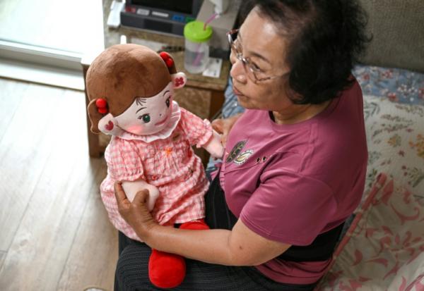 Bang Chun-ja, une Sud-Coréenne de 78 ans vivant seule, tient sa poupée IA Hyodol, le 29 avril 2026 à Yongin, en Corée du Sud