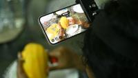 Nagireddy Sriramyachandra filme avec un téléphone ses gestes pendant qu'elle coupe une mangue pour entraîner un futur robot dopé à l'IA, le 15 mai 2026 à Madras, en Inde