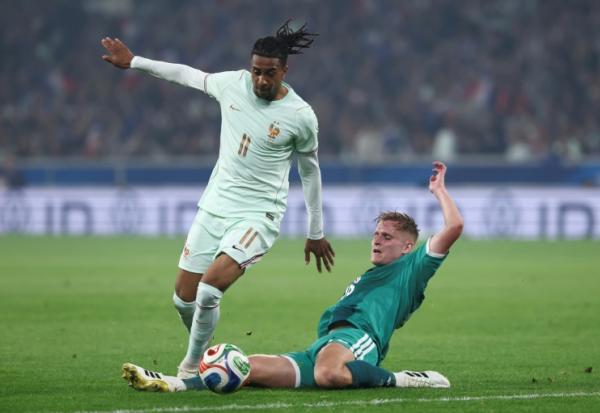 Michael Olise tente d'échapper à un défenseur nord-irlandais lors de la victoire de l'équipe de France en match amical de préparation au Mondial, le 8 juin 2026 à Villeneuve-d'Ascq