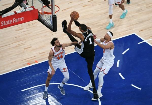 Le basketteur français des San Antonio Spurs Victor Wembanyama tire au panier sous la défense de Landry Shamet et de Josh Hart des New York Knicks, lors du troisième match de la finale de la NBA au Madison Square Garden de New York, le 8 juin 2026