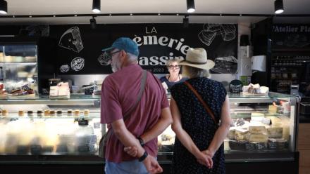 Des clients se font servir chez un fromager au marché d'Andernos-les-Bains, en Gironde, le 1er août 2026