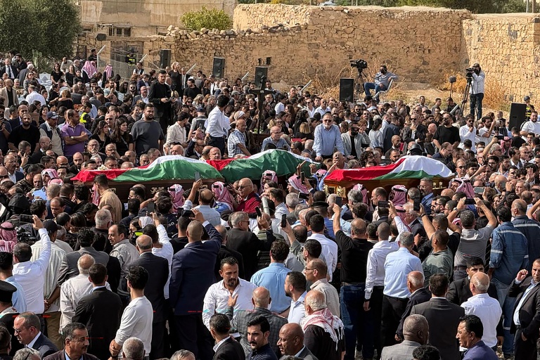 Des hommes portent les corps des personnes tuées lors d'une attaque contre une église, lors de leurs obsèques dans le village de Hammoud, dans le sud de la Jordanie, le 25 octobre 2026