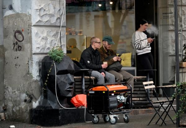 Un générateur en marche devant un café à Kiev durant une coupure de courant causée par des frappes russes sur des installations électriques, le 18 octobre 2026