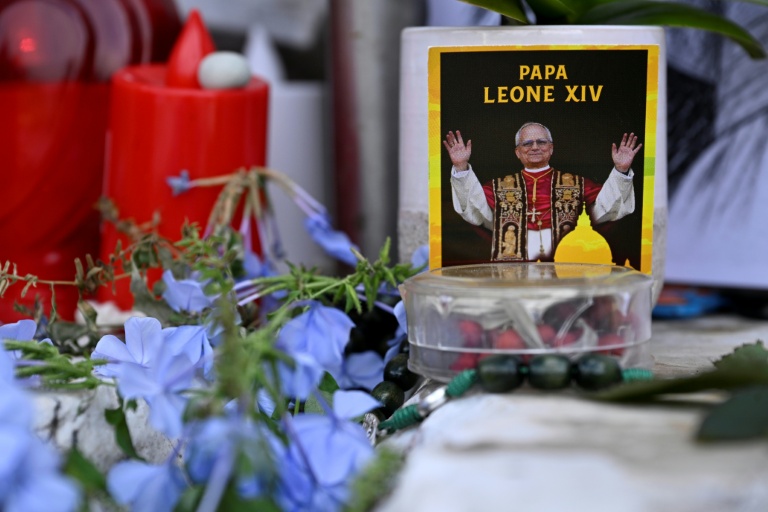 Des fleurs, des bougies et une photo du pape Léon XIV déposées au pied de la statue de Jean Paul II, devant l’hôpital Gemelli à Rome où le pape Léon XIV est en convalescence, le 17 octobre 2026