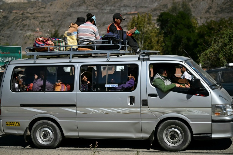 Des personnes voyagent sur le toit d'un minivan chargé après la réouverture d'une route, auparavant bloquée par des  manifestations réclamant la démission du président bolivien Rodrigo Paz à Carreras, dans le département de La Paz, en Bolivie, le 5 juin 2026