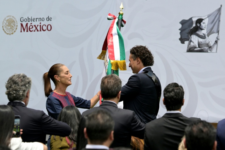 La présidente Claudia Sheinbaum remet le drapeau national au gardien de but Guillermo Ochoa, lors d'une cérémonie en l'honneur de l'équipe nationale de football du Mexique avant la Coupe du monde de la Fifa, le 8 juin 2026 à Mexico