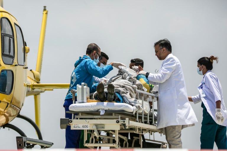 Les secouristes et le personnel médical transfèrent le guide Dawa Sherpa à son arrivée à l'hôpital de Katmandou le 4 juin 2026