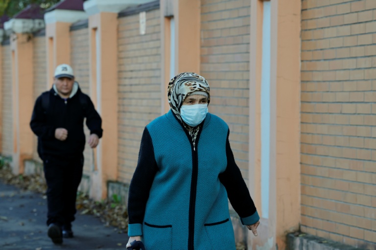 Une femme porte un masque de protection alors qu'elle passe près de l'institut de lutte contre la peste à Irkoutsk, le 7 octobre 2026 en Russie