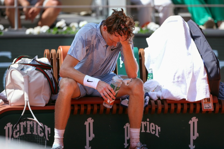 Le N.1 mondial Jannik Sinner tente de se rafraîchir sous une chaleur accablante, lors de son match finalement perdu face à l'Argentin Manuel Cerundolo, le 28 mai 2026 à Roland-Garros