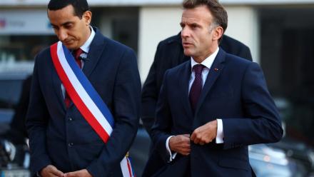 Le président français Emmanuel Macron (D) marche aux côtés du maire de Trappes, Ali Rabeh, à son arrivée pour une réunion à l'hôtel de ville après une fusillade survenue à Trappes, le 23 octobre 2026