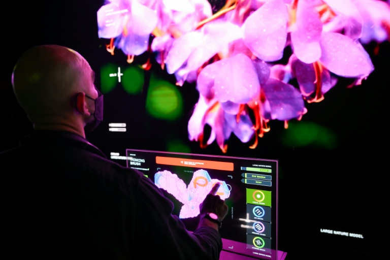 Un visiteur touche un écran pour interagir avec des visualisations immersives de l'exposition 