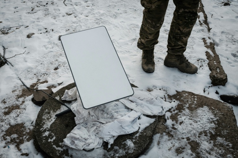 Un soldat ukrainien à côté d'une antenne du système par satellite Starlink à Bakhmout, le 9 février 2023